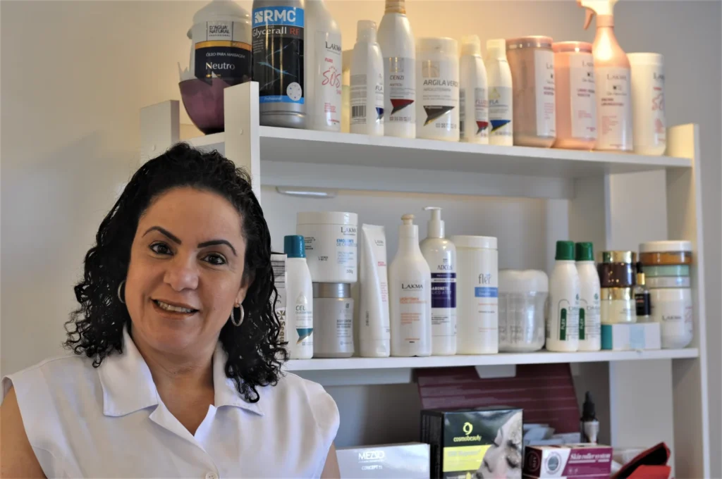 Dra. Denise Lopes sorrindo em retrato com uniforme branco